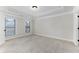 A neutral bedroom with carpet, tray ceiling, two windows, and a closet door at 3585 Adelaide Xing, Brookhaven, GA 30319