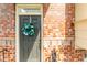 Close up of the front door featuring a festive wreath and brick surround adding warmth and charm at 3585 Adelaide Xing, Brookhaven, GA 30319