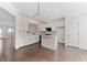 Open-concept kitchen with white cabinets, a central island, granite countertops, and hardwood flooring at 3585 Adelaide Xing, Brookhaven, GA 30319