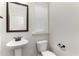 A simple powder room has a pedestal sink, toilet, neutral paint, and a window with blinds at 3585 Adelaide Xing, Brookhaven, GA 30319