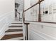 Elegant staircase with wooden steps and white railings leading to the upper levels of the home at 3585 Adelaide Xing, Brookhaven, GA 30319