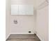 Laundry room with wood look floors, overhead storage cabinets, and washer hookups at 3698 Fairlane Nw Dr, Atlanta, GA 30331