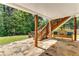 Covered stone patio with stairs leading to the backyard, offering a cozy bench for relaxing and enjoying the outdoors at 3835 Annandale Ln, Suwanee, GA 30024