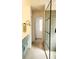 Bright bathroom featuring modern vanity, sleek shower with glass doors, and tile flooring at 3835 Annandale Ln, Suwanee, GA 30024
