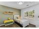 This bedroom features a large window for natural light, a custom accent wall and hardwood floors at 3835 Annandale Ln, Suwanee, GA 30024