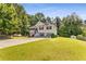 Traditional home with a well-manicured lawn and mature trees in a residential neighborhood at 3835 Annandale Ln, Suwanee, GA 30024