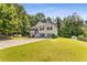 Inviting two-story home with a spacious front yard and driveway leading to a charming facade with well-manicured landscaping at 3835 Annandale Ln, Suwanee, GA 30024