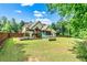 Expansive backyard featuring a playset, screened porch, lush lawn, and wooden fence at 100 Chantilly Ln, Fayetteville, GA 30215