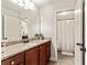 Well-lit bathroom featuring a granite countertop vanity, a large mirror, and a separate shower area at 100 Chantilly Ln, Fayetteville, GA 30215