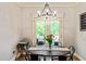 Cozy dining area featuring modern chandelier, wood table with seating and natural light from French doors at 100 Chantilly Ln, Fayetteville, GA 30215