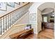 Inviting entryway with hardwood floors, bench seating, and an open staircase with decorative iron railings at 100 Chantilly Ln, Fayetteville, GA 30215