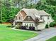 Stunning home exterior with stone accents, lush landscaping, a spacious driveway, and attached two-car garage at 100 Chantilly Ln, Fayetteville, GA 30215