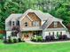 Beautiful home exterior with manicured landscaping, a covered porch, and a combination of stone and siding at 100 Chantilly Ln, Fayetteville, GA 30215