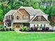 Beautiful two-story home with stone and shake siding, well-manicured lawn, and professional landscaping at 100 Chantilly Ln, Fayetteville, GA 30215