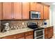 Modern kitchen with granite countertops, stainless steel appliances, and ample wooden cabinetry at 100 Chantilly Ln, Fayetteville, GA 30215
