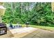 Backyard patio with a built-in grill, perfect for entertaining, surrounded by mature trees at 100 Chantilly Ln, Fayetteville, GA 30215