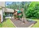 Backyard with wooden playground structure, surrounded by green grass and mature trees, ideal for outdoor fun at 100 Chantilly Ln, Fayetteville, GA 30215