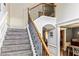 Carpeted staircase with wrought iron railing, complemented by wainscoting and adjacent dining area at 100 Chantilly Ln, Fayetteville, GA 30215
