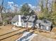 Beautiful home featuring a gray roof, white and gray paint, a chimney, and a large manicured lawn at 1571 Boulevard Lorraine Sw, Atlanta, GA 30311