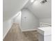 Unfinished attic area features neutral carpet, white walls, and sloped ceilings at 1571 Boulevard Lorraine Sw, Atlanta, GA 30311
