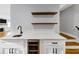 Custom bar area featuring a sleek countertop, wine refrigerator, and contemporary sink with modern fixtures at 1571 Boulevard Lorraine Sw, Atlanta, GA 30311