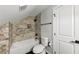 Bathroom with a bathtub, toilet, decorative tile wall and black accents at 1571 Boulevard Lorraine Sw, Atlanta, GA 30311