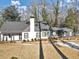 Attractive home featuring a gray roof, white and gray paint, a chimney, and a manicured lawn at 1571 Boulevard Lorraine Sw, Atlanta, GA 30311