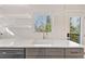 Bright kitchen with a modern sink, quartz countertops, gray cabinets, and stainless steel dishwasher at 1571 Boulevard Lorraine Sw, Atlanta, GA 30311
