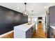 Stunning kitchen island featuring quartz countertops and modern pendant lighting that illuminates the open floor plan at 1571 Boulevard Lorraine Sw, Atlanta, GA 30311