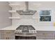 Modern kitchen featuring stainless steel range hood, gas range and white subway tile backsplash at 1571 Boulevard Lorraine Sw, Atlanta, GA 30311
