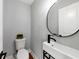 Chic powder room featuring a modern vanity, vessel sink, sleek faucet, and round mirror that adds a touch of elegance at 1571 Boulevard Lorraine Sw, Atlanta, GA 30311