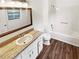 Bathroom features vinyl flooring, a shower-tub combo, and single sink vanity with a large rectangular mirror at 2325 Sebring Sw Ct, Marietta, GA 30064