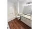 Bright bathroom with a tub, shower, wood-look flooring, and a single sink vanity with marble countertop at 2325 Sebring Sw Ct, Marietta, GA 30064