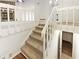 A carpeted staircase connecting upper and lower levels, featuring white railings, and a glimpse into the lower floor at 2325 Sebring Sw Ct, Marietta, GA 30064