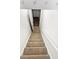 A carpeted staircase leading down, revealing wood floors, with white walls and railings providing a bright path at 2325 Sebring Sw Ct, Marietta, GA 30064