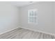 Bright bedroom with a window offering natural light and modern light gray plank flooring at 3453 Dianthus Ln, Lawrenceville, GA 30044