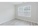 This bedroom features new light wood flooring and a bright window with stylish blinds at 3453 Dianthus Ln, Lawrenceville, GA 30044