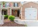 Inviting townhome entrance featuring a brick facade, covered porch, and a well-maintained front yard at 3453 Dianthus Ln, Lawrenceville, GA 30044