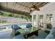 Back patio includes ceiling fan, outdoor furniture and a view of the backyard pool surrounded by a stone retaining wall at 6300 Mountain Brook Ln, Atlanta, GA 30328