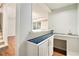 Basement bar area with blue tiled countertop, white cabinets, and view to finished basement at 6300 Mountain Brook Ln, Atlanta, GA 30328