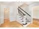 Inviting entryway featuring hardwood floors, elegant staircase, and classic wainscoting detail at 6300 Mountain Brook Ln, Atlanta, GA 30328