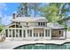 Rear exterior view of this beautiful home, showing the sunroom, patio, in-ground pool, and mature landscaping at 6300 Mountain Brook Ln, Atlanta, GA 30328