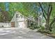 Side view of brick and white house featuring a spacious driveway and mature landscaping at 6300 Mountain Brook Ln, Atlanta, GA 30328
