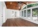 Bright sunroom boasts hardwood floors, brick accent wall, and large windows overlooking the outdoor pool area at 6300 Mountain Brook Ln, Atlanta, GA 30328
