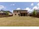 Expansive backyard featuring lush green lawn, privacy fence, and covered patio on a sunny day at 133 Canal St, Hampton, GA 30228