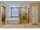 Primary bathroom showcasing a glass door shower, large soaking tub, and neutral tile floors at 133 Canal St, Hampton, GA 30228