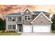 Beautiful two-story home showcasing a blend of brick and stone, complemented by a two-car garage and welcoming front door at 133 Canal St, Hampton, GA 30228