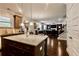 Open concept kitchen with granite island, stainless appliances, seamless transition to living area, and hardwood floors at 133 Canal St, Hampton, GA 30228