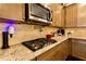 Close-up of a kitchen featuring stainless steel appliances, granite countertops, tile backsplash, and ample cabinet space at 133 Canal St, Hampton, GA 30228