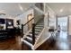 Open-concept living area with a staircase, hardwood floors, and elegant decor leading to the entryway at 133 Canal St, Hampton, GA 30228